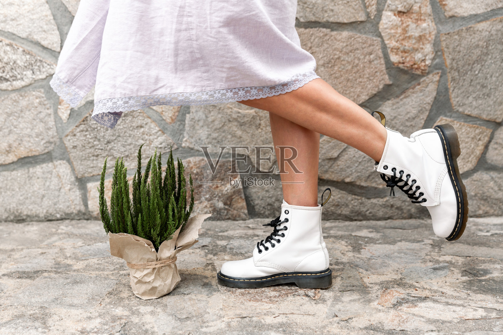 穿着白色粗靴和盆栽的女人的腿照片摄影图片