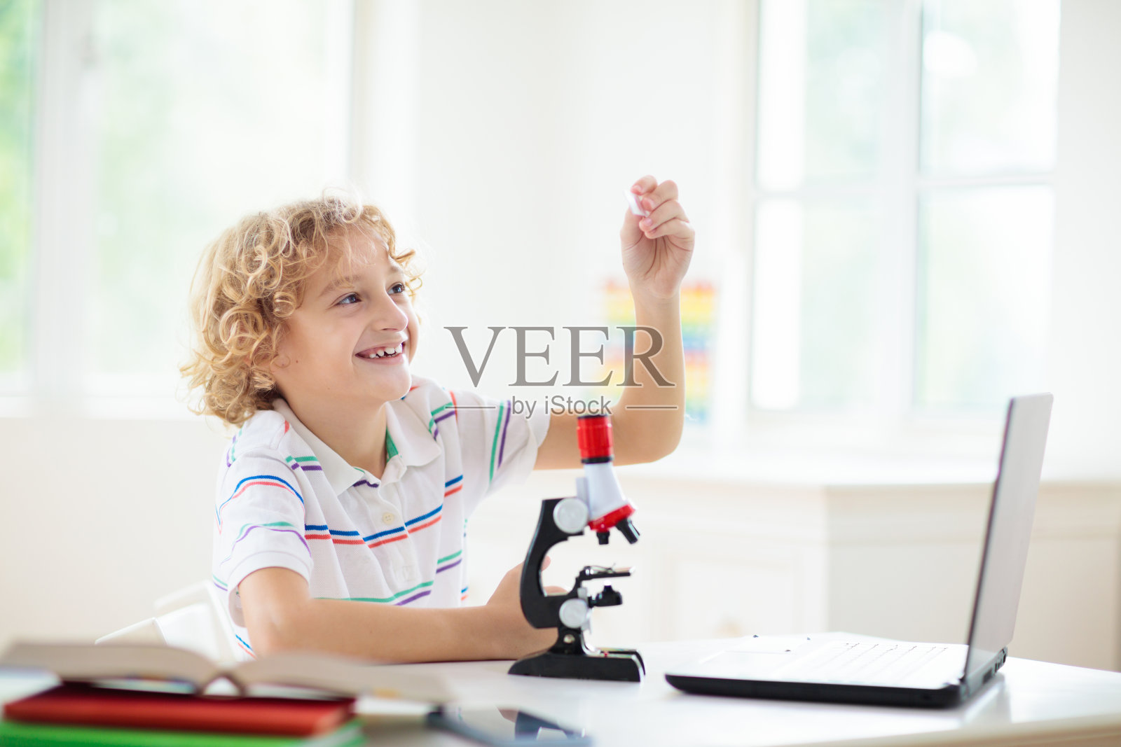 小学生拿着显微镜。科学课。照片摄影图片