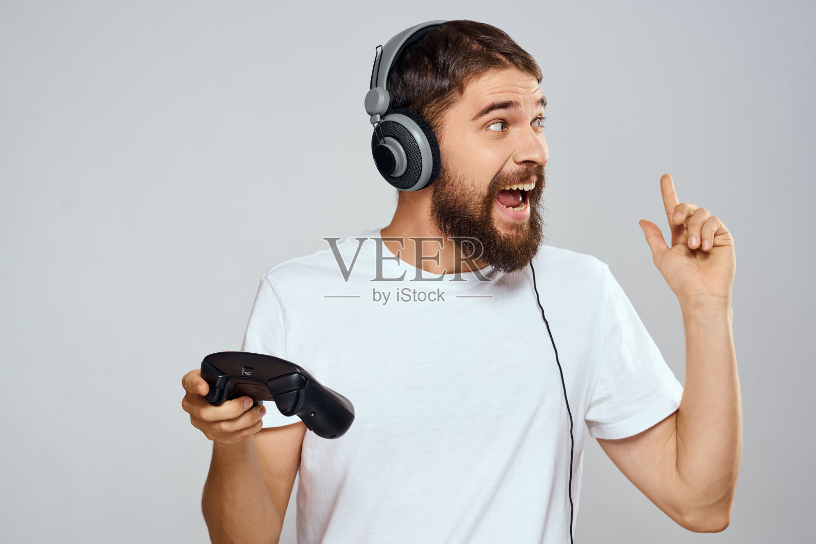 男人戴着耳机带着手柄玩爱好娱乐生活方式光背景照片摄影图片