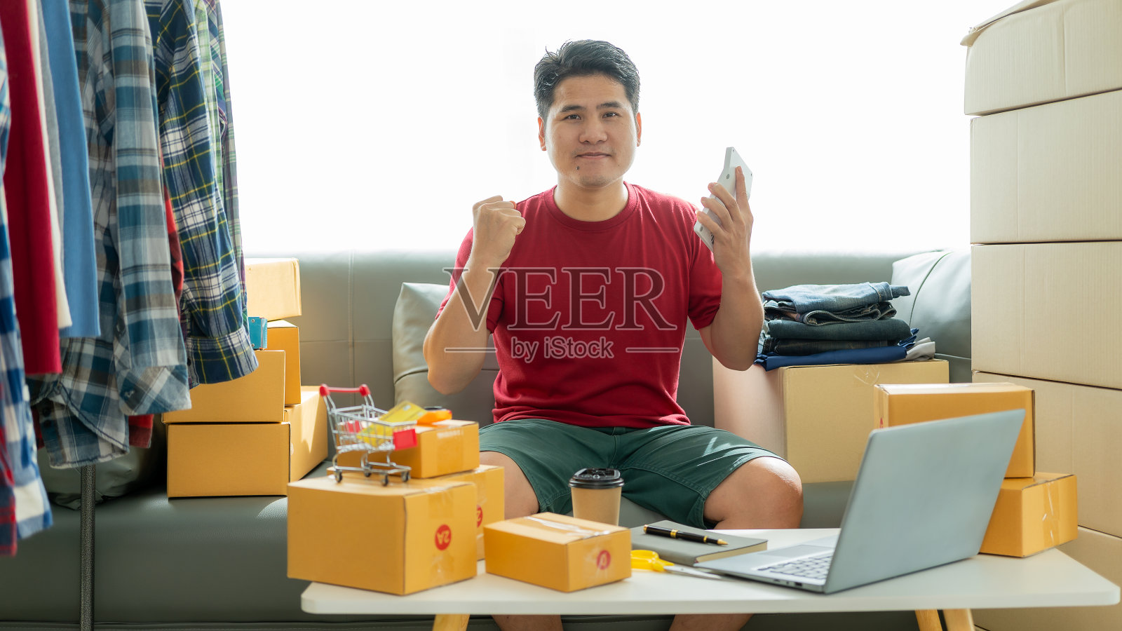 网店老板在网上检查网站上的订单，与客户确认订单，并将产品包装在包裹箱中发货。中小企业概念网上销售产品照片摄影图片