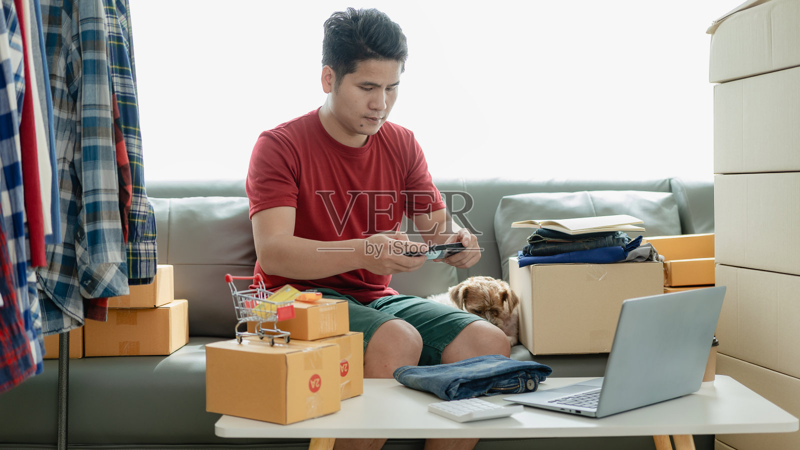 网店老板在网上检查网站上的订单，与客户确认订单，并将产品包装在包裹箱中发货。中小企业概念网上销售产品照片摄影图片