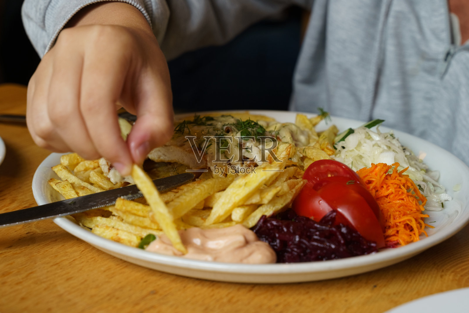 随性的用餐体验，一盘混合餐和手照片摄影图片