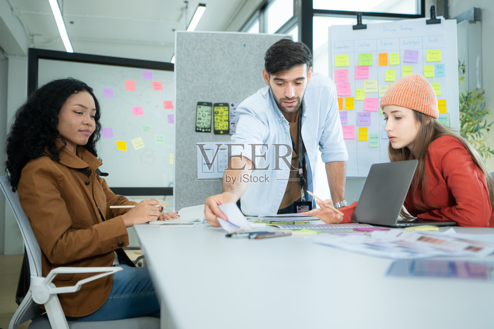 多民族的年轻商务人士在现代办公室里一起工作，协作设计一个应用程序用于互联网网络。照片摄影图片