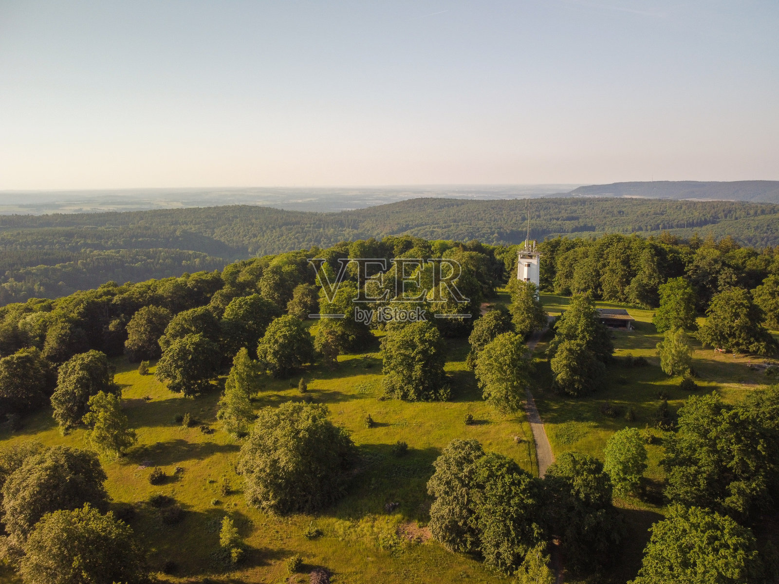 航拍的绿色森林地区的一座白塔。巴伐利亚森林景观。照片摄影图片