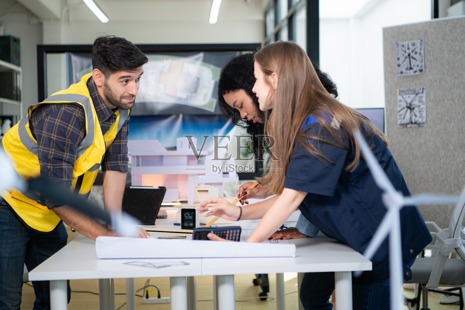 工程师、建筑师和设计师合作设计一座利用自然能源的建筑。照片摄影图片