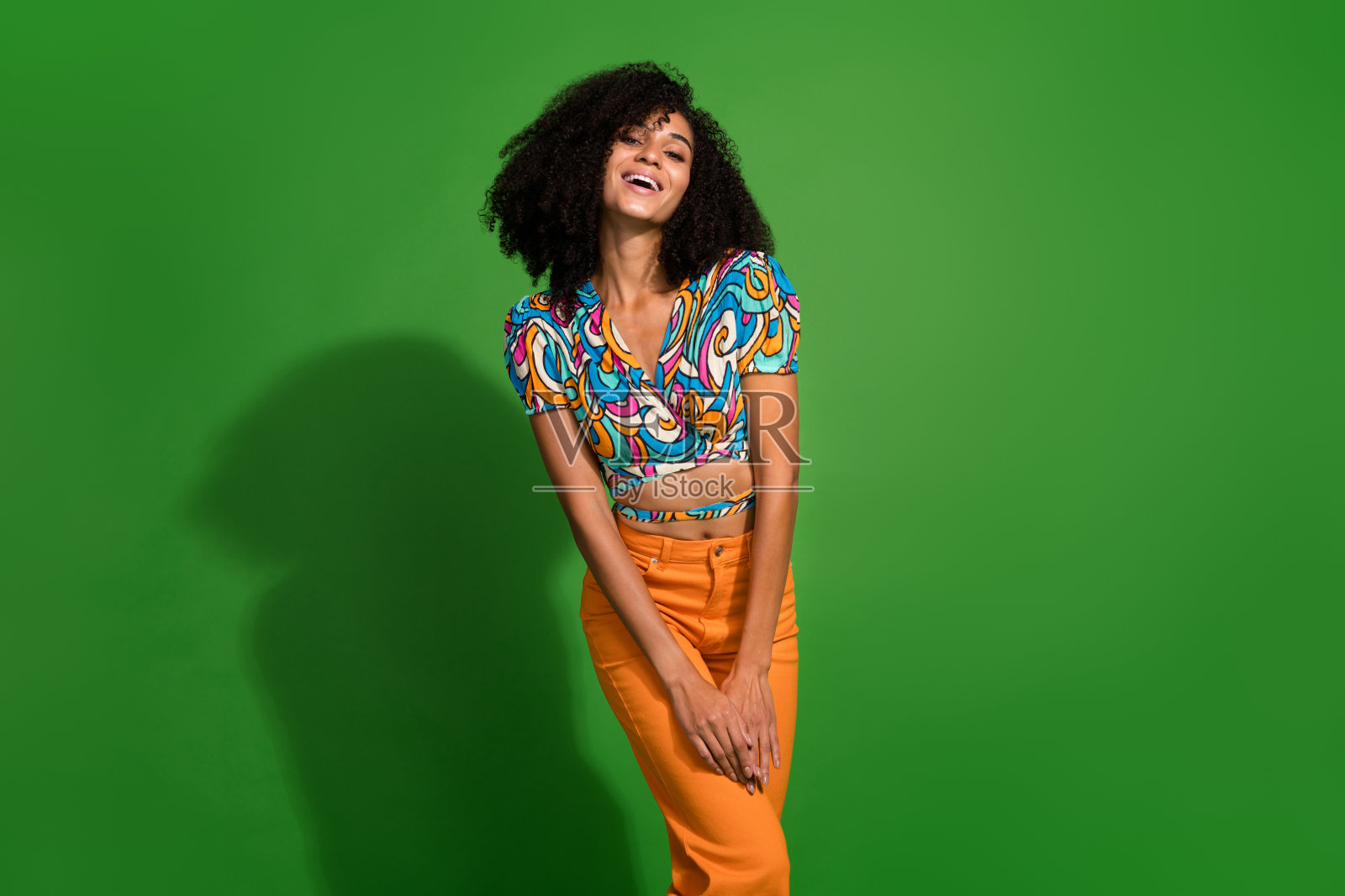 照片的开朗积极漂亮可爱的魅力女士穿着鲜艳鲜艳的印花衣服孤立在绿色的背景照片摄影图片