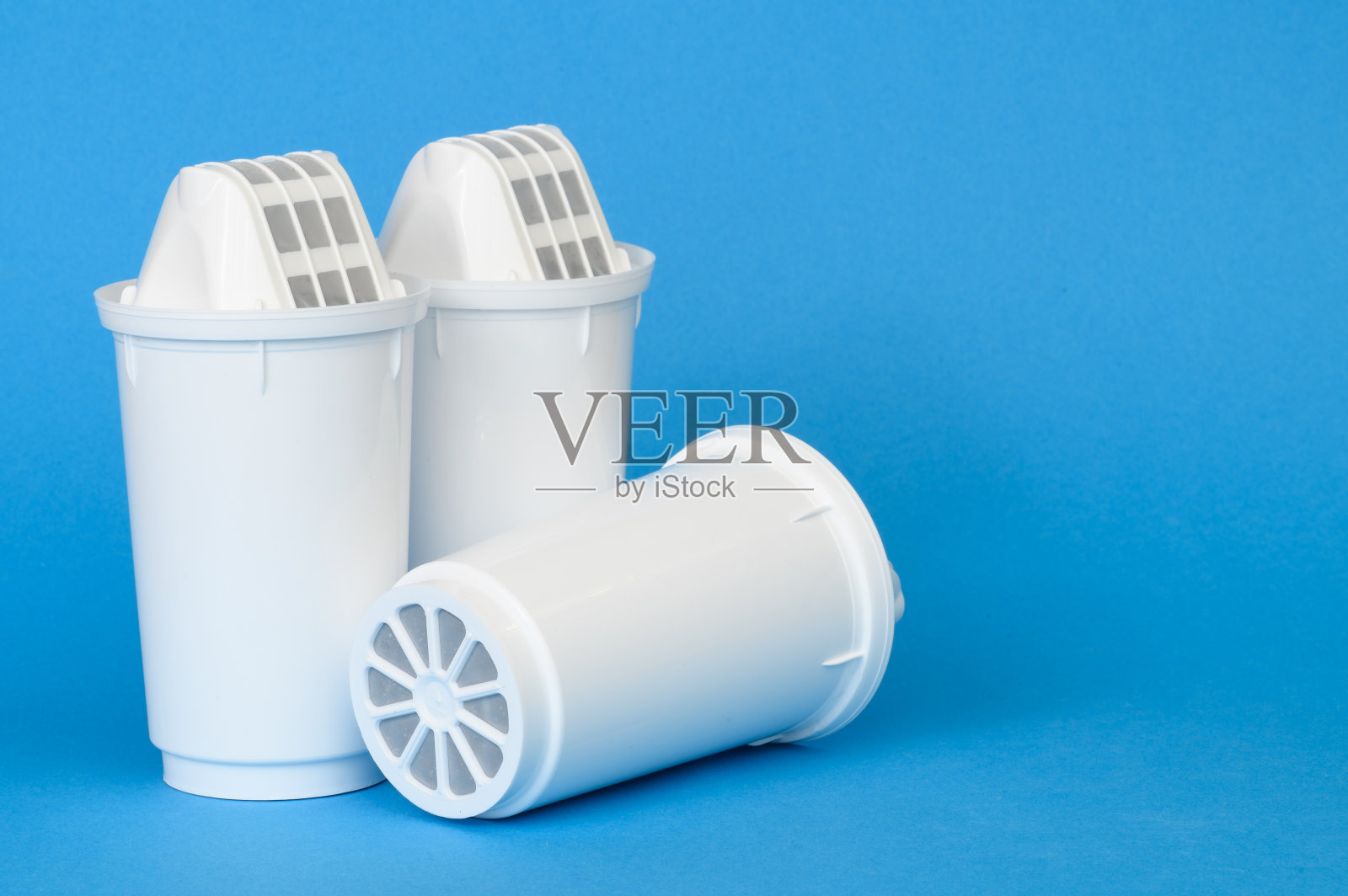 三个新的水净化滤芯，蓝色背景，特写。水净化概念，去除水中不溶性杂质、金属。世界水日照片摄影图片