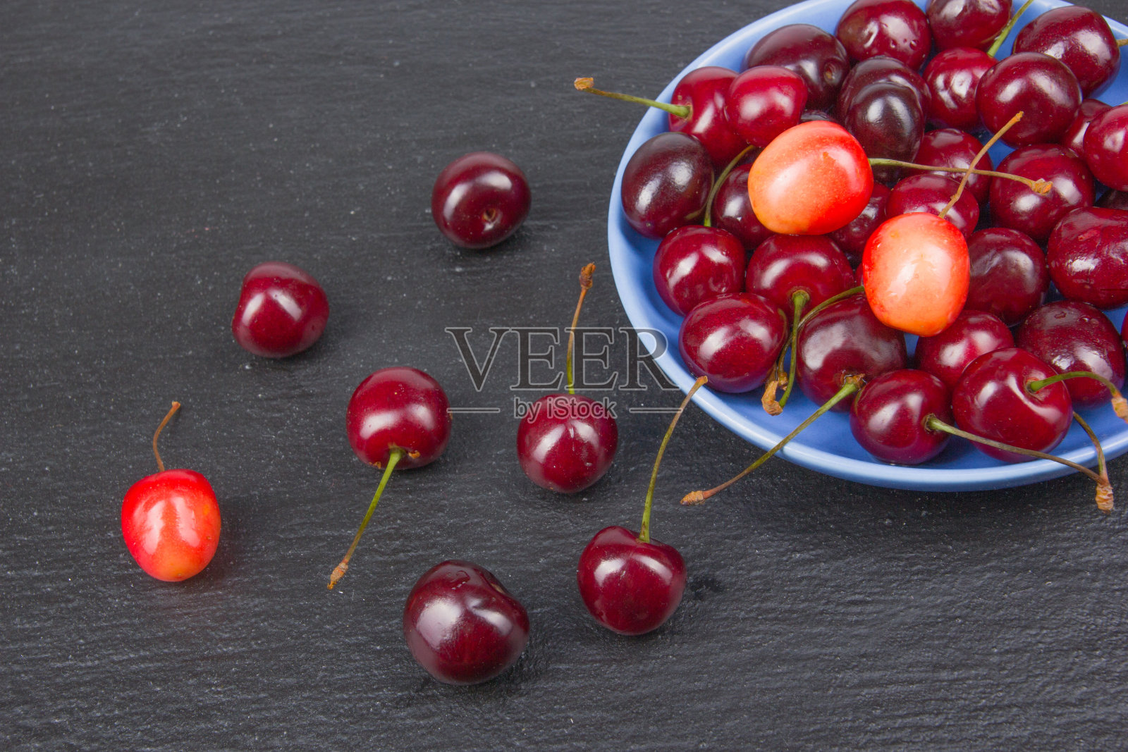 各种夏天的新鲜樱桃在一个碗在质朴的木桌。抗氧化剂，排毒饮食，有机水果。浆果照片摄影图片