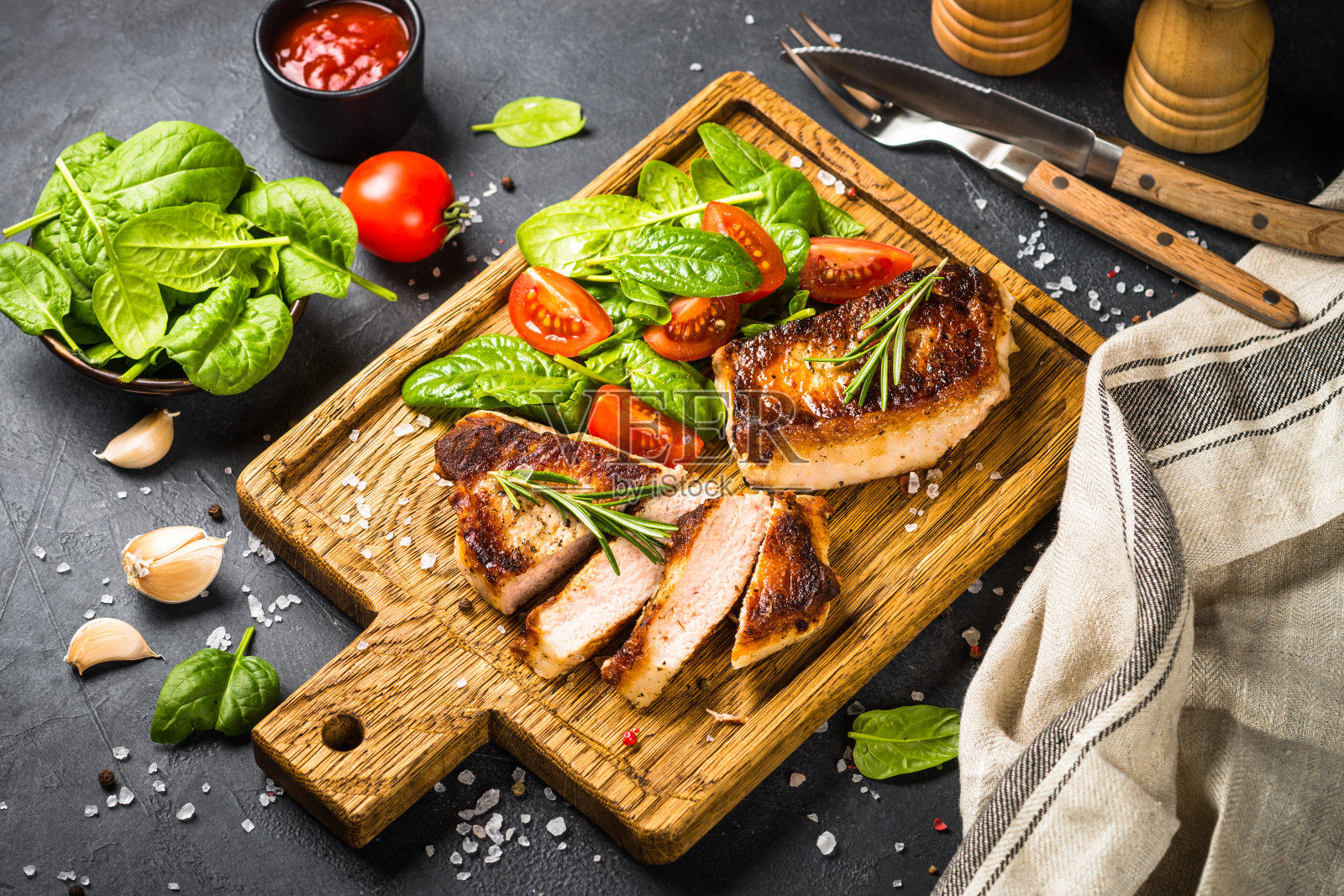 肉排配新鲜的沙拉在木板上供应。照片摄影图片