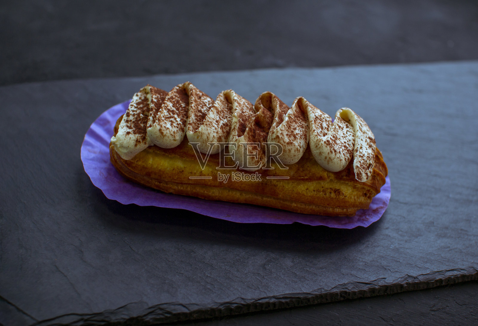 美味的泡芙蛋糕-提拉米苏口味，覆盖着奶油照片摄影图片