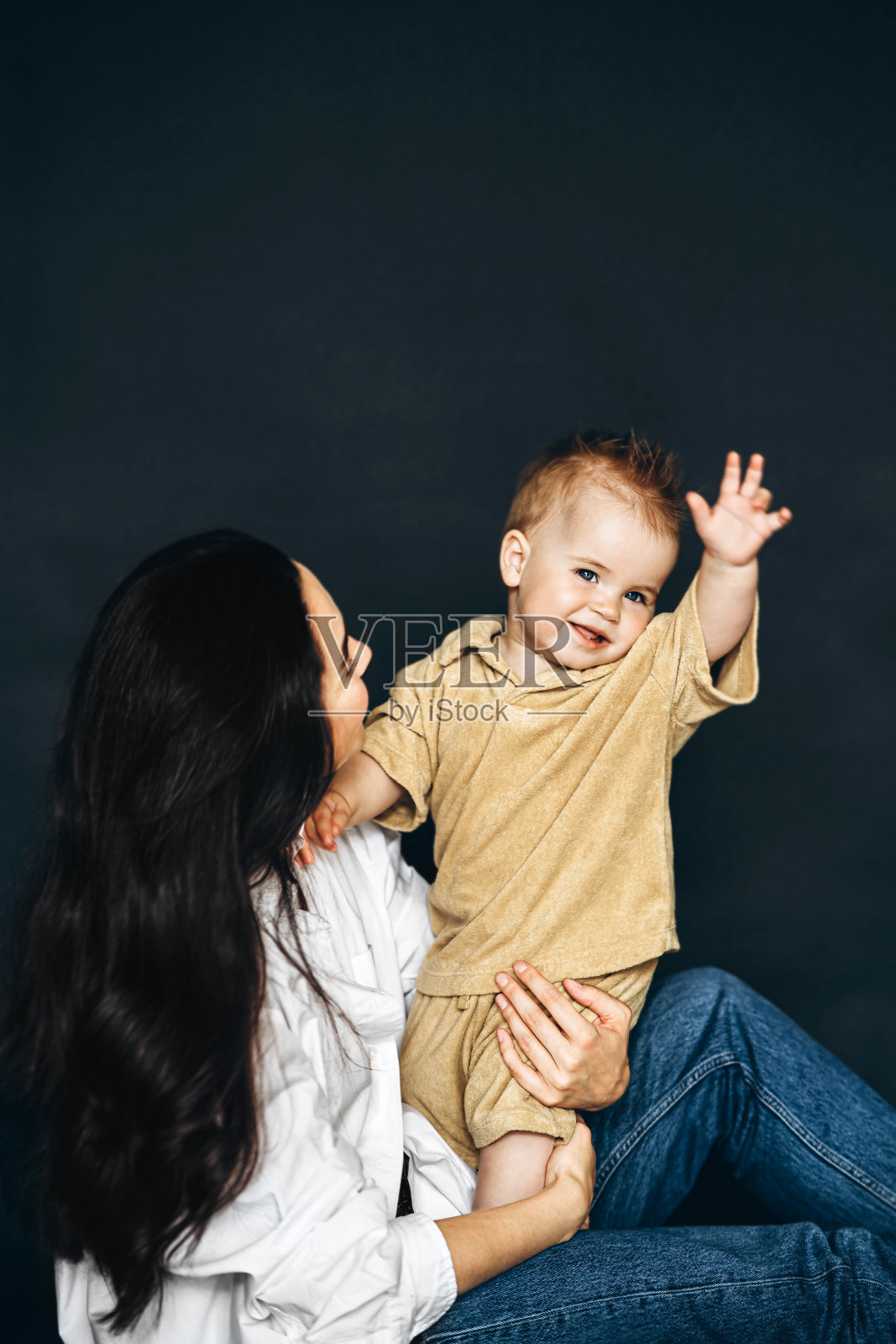 把婴儿抱在腿上的妇女照片摄影图片