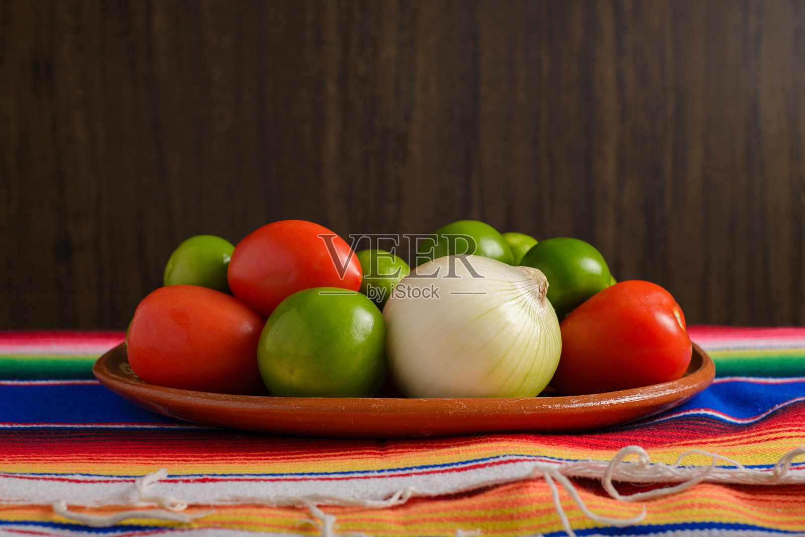 水果和蔬菜放在传统的墨西哥泥盘上。五月五日节庆祝背景。照片摄影图片