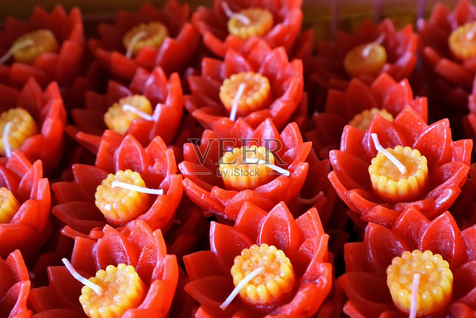 一盘红色蜡烛和黄色花朵的照片。照片摄影图片