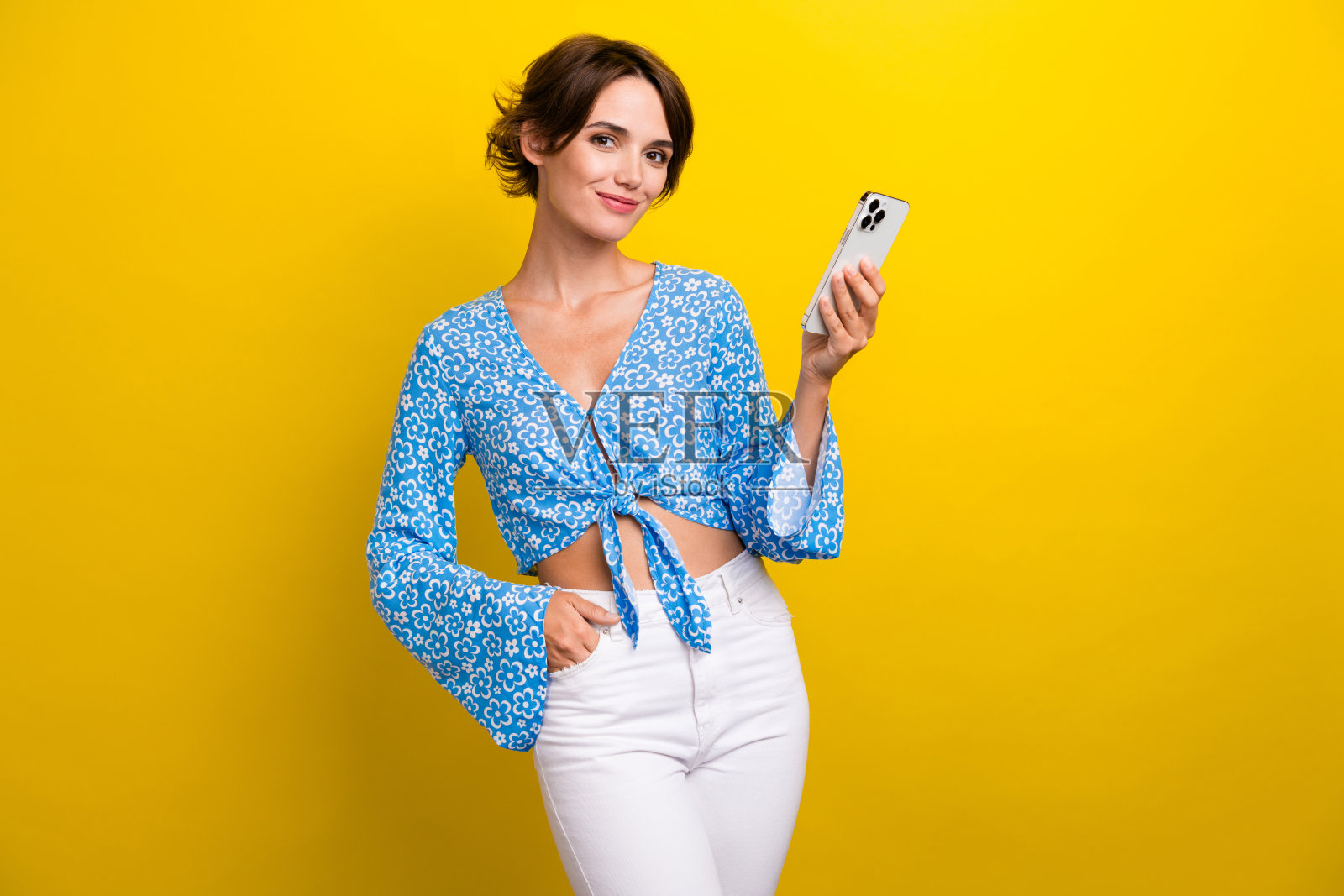 积极好心情的年轻女子穿着印花衬衫的照片传达了现代装置孤立的黄色背景照片摄影图片