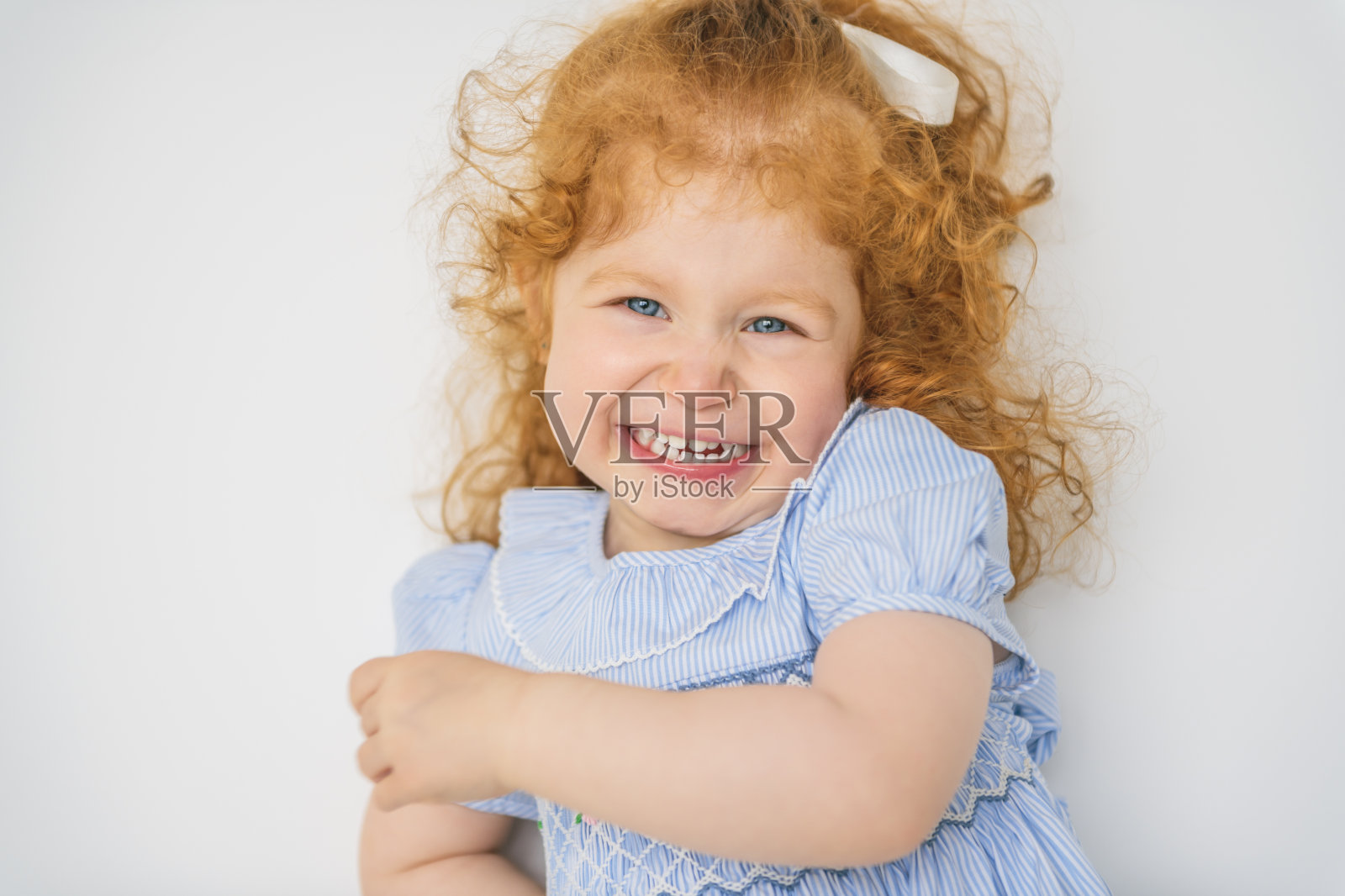 穿着红发裙子的可爱小女孩。孩子两岁了。照片摄影图片