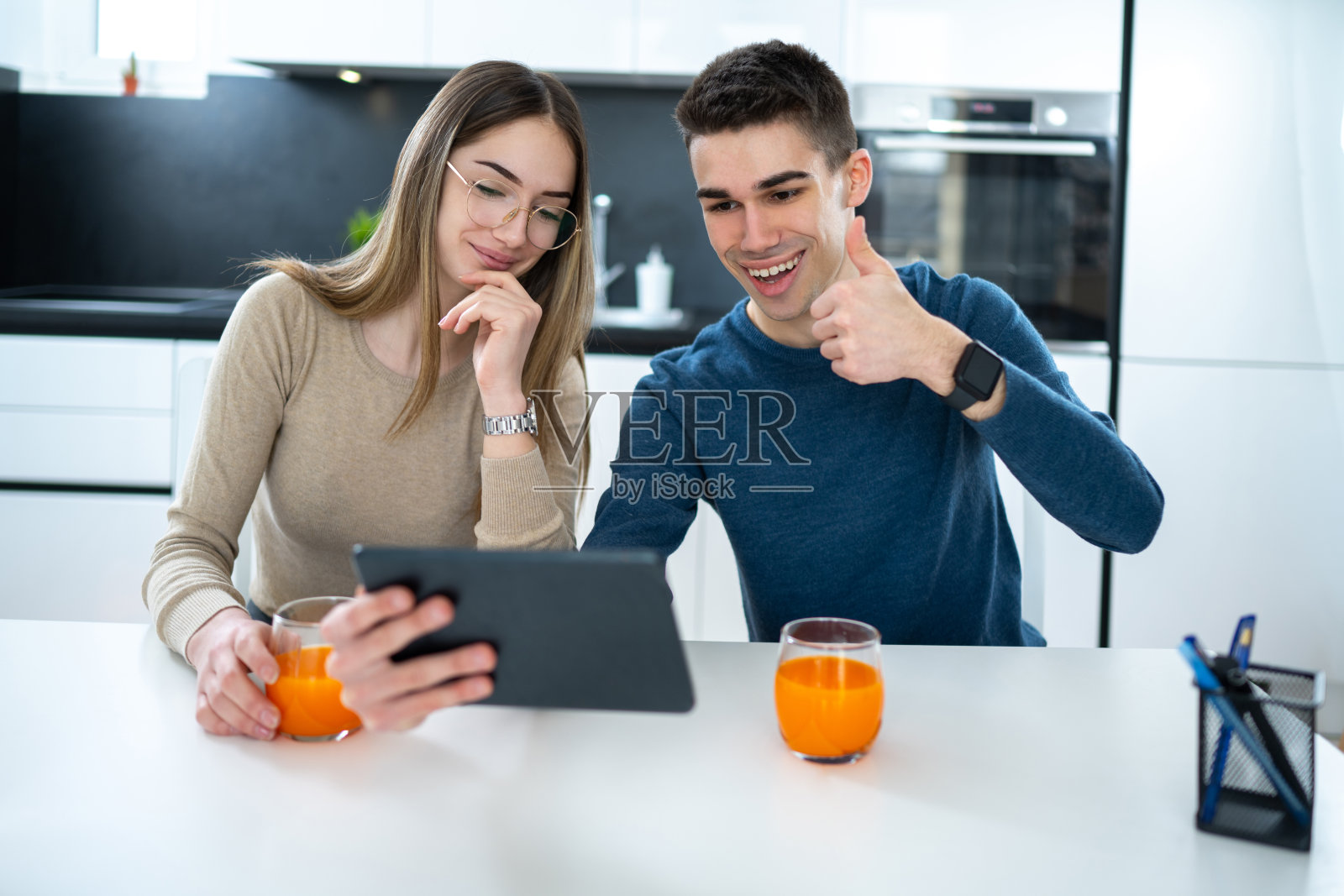 年轻夫妇在视频通话中与家人交谈并竖起大拇指。照片摄影图片