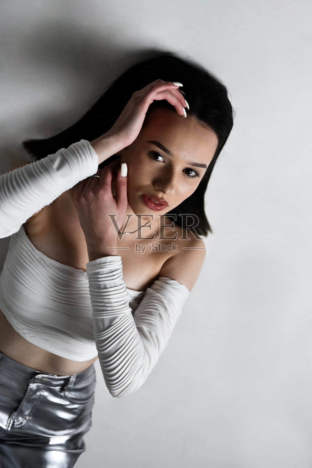 白色露脐上衣和银色裤子的美女肖像照片摄影图片