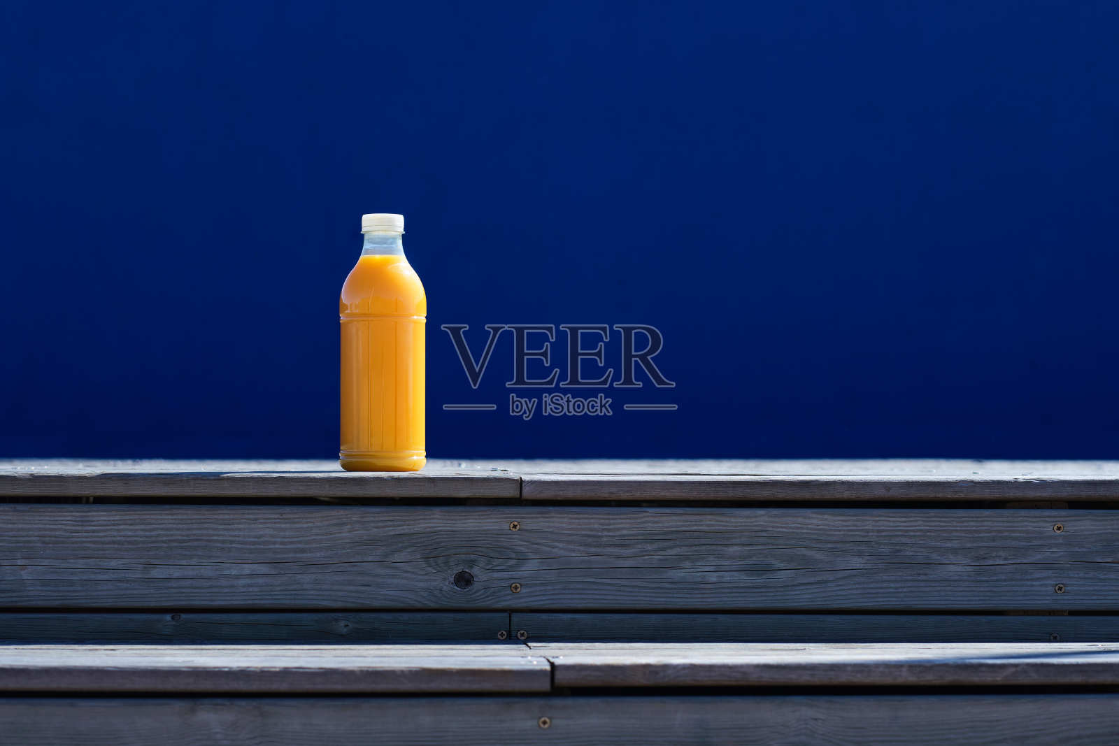 一个标准的透明塑料瓶PET与橙汁在阳光明媚的日子里在户外的一般镜头照片摄影图片