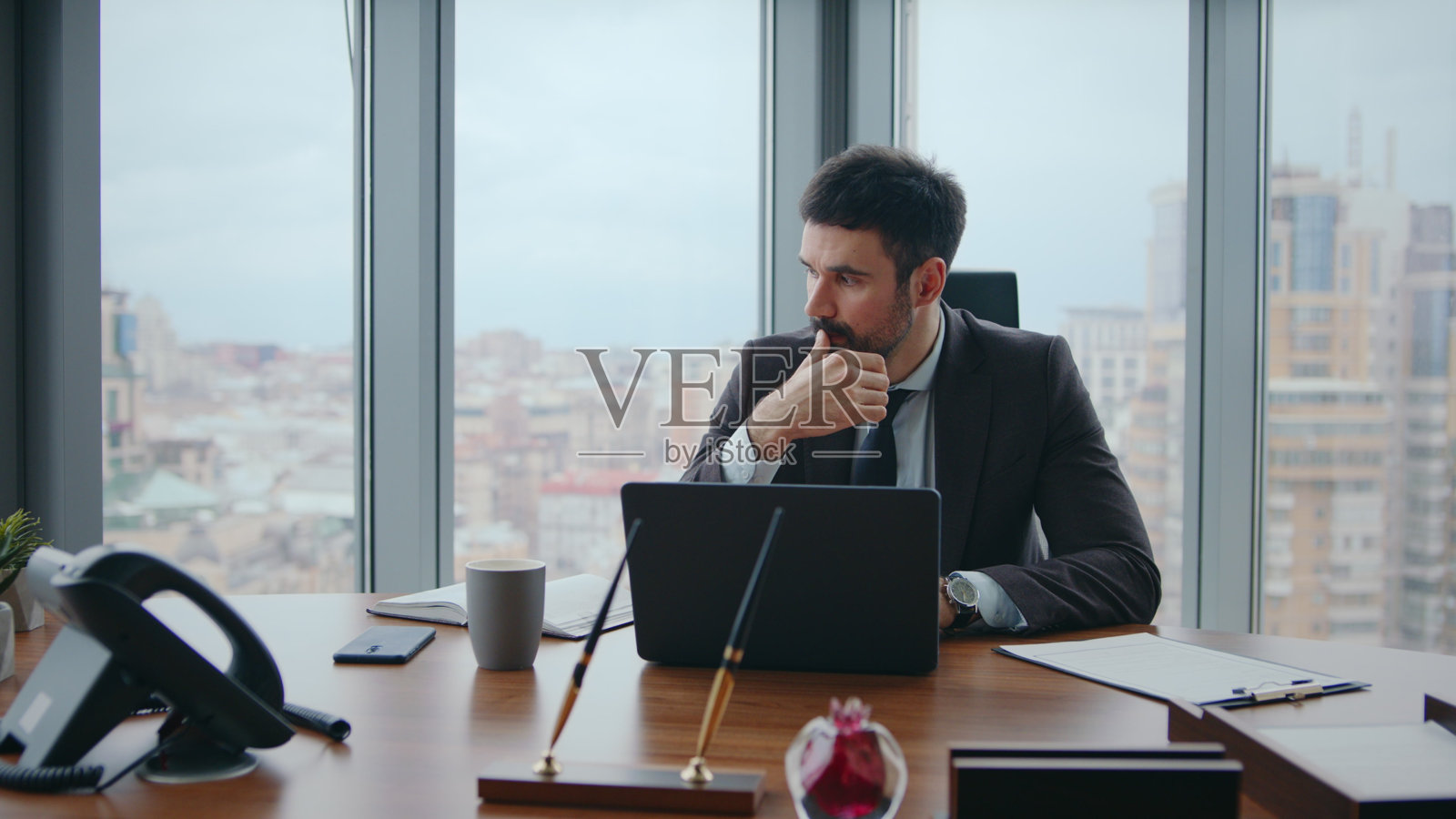 忙碌的上班族坐在豪华的办公场所思考公司危机。照片摄影图片