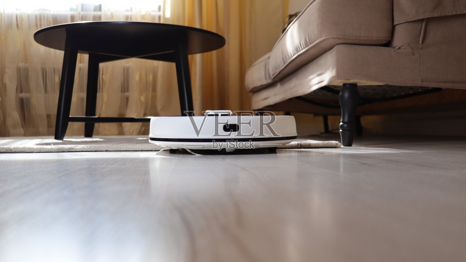 地板和客厅地毯上的机器人真空吸尘器照片摄影图片