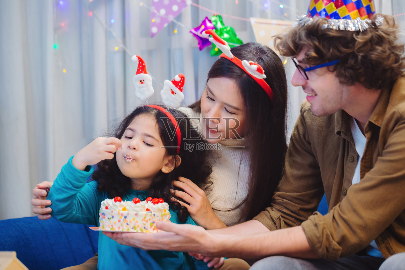 庆祝小女孩的生日，在室内，在自制的烤蛋糕上吹蜡烛。小女孩的生日聚会照片摄影图片