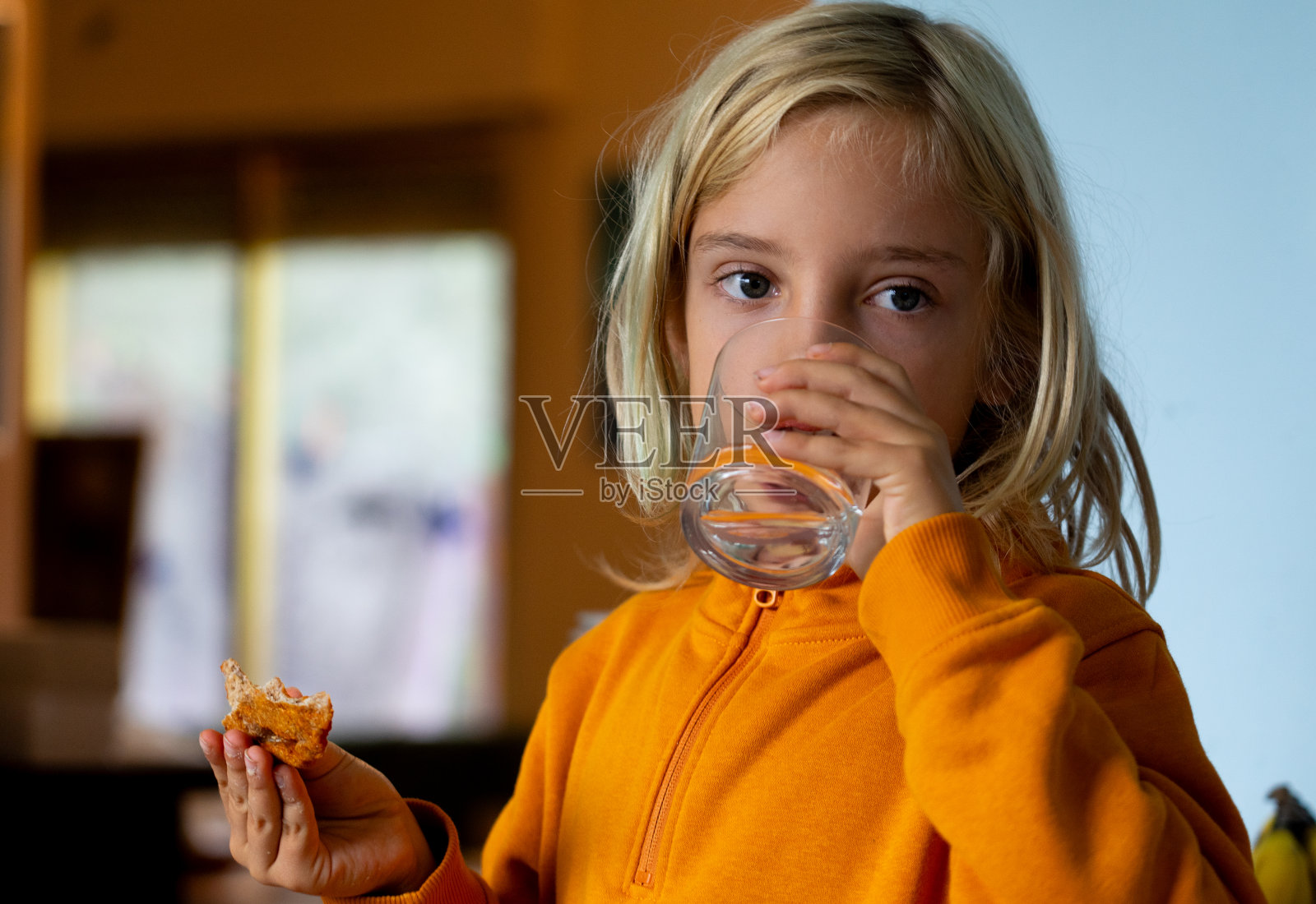 男孩一边吃披萨一边喝水照片摄影图片