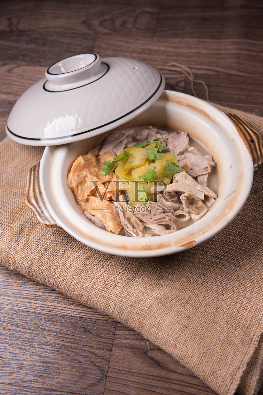 红烧煮猪肉猪肉猪胃豆腐皮酸菜草药和白胡椒健康热汤砂锅木桌亚洲中国清真食品宴会餐厅菜单照片摄影图片