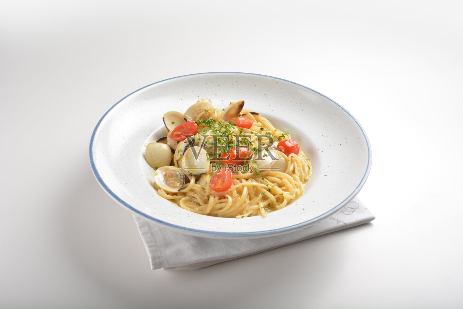 橄榄油混合海鲜蛤壳意面在aglio olio风格和圣女果在盘子白色背景酒店餐厅西餐厅清真美食菜单照片摄影图片