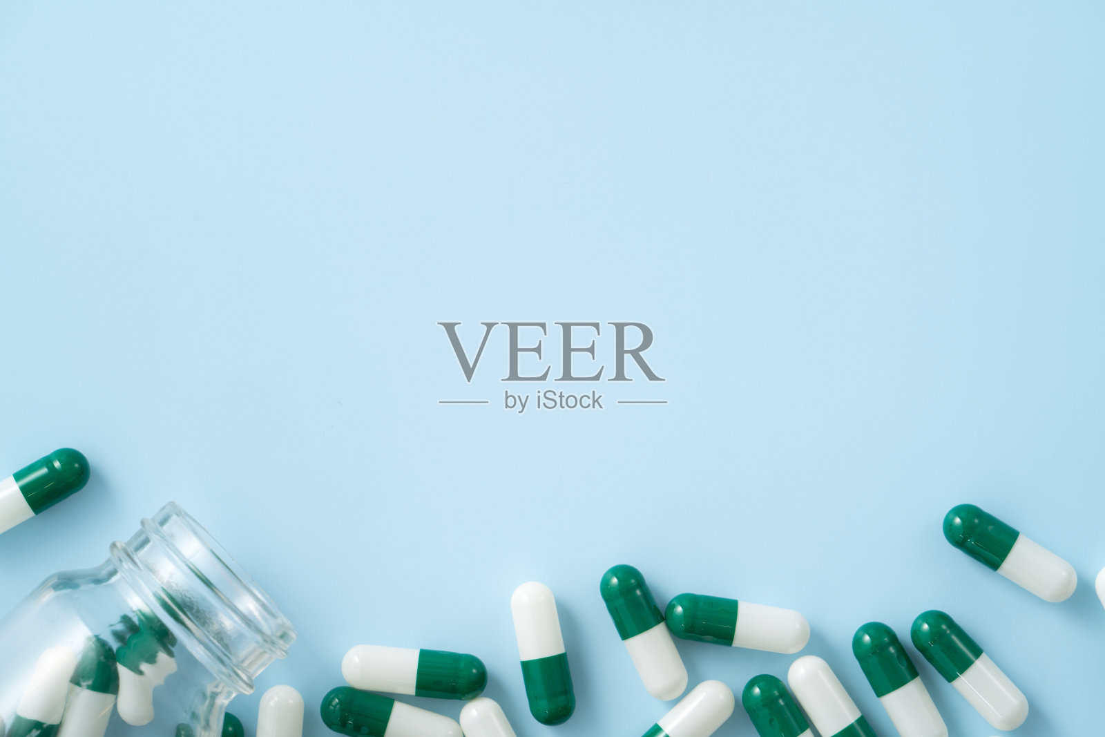 服用药物的设计理念，蓝色表格背景上的胶囊药丸俯视图。照片摄影图片