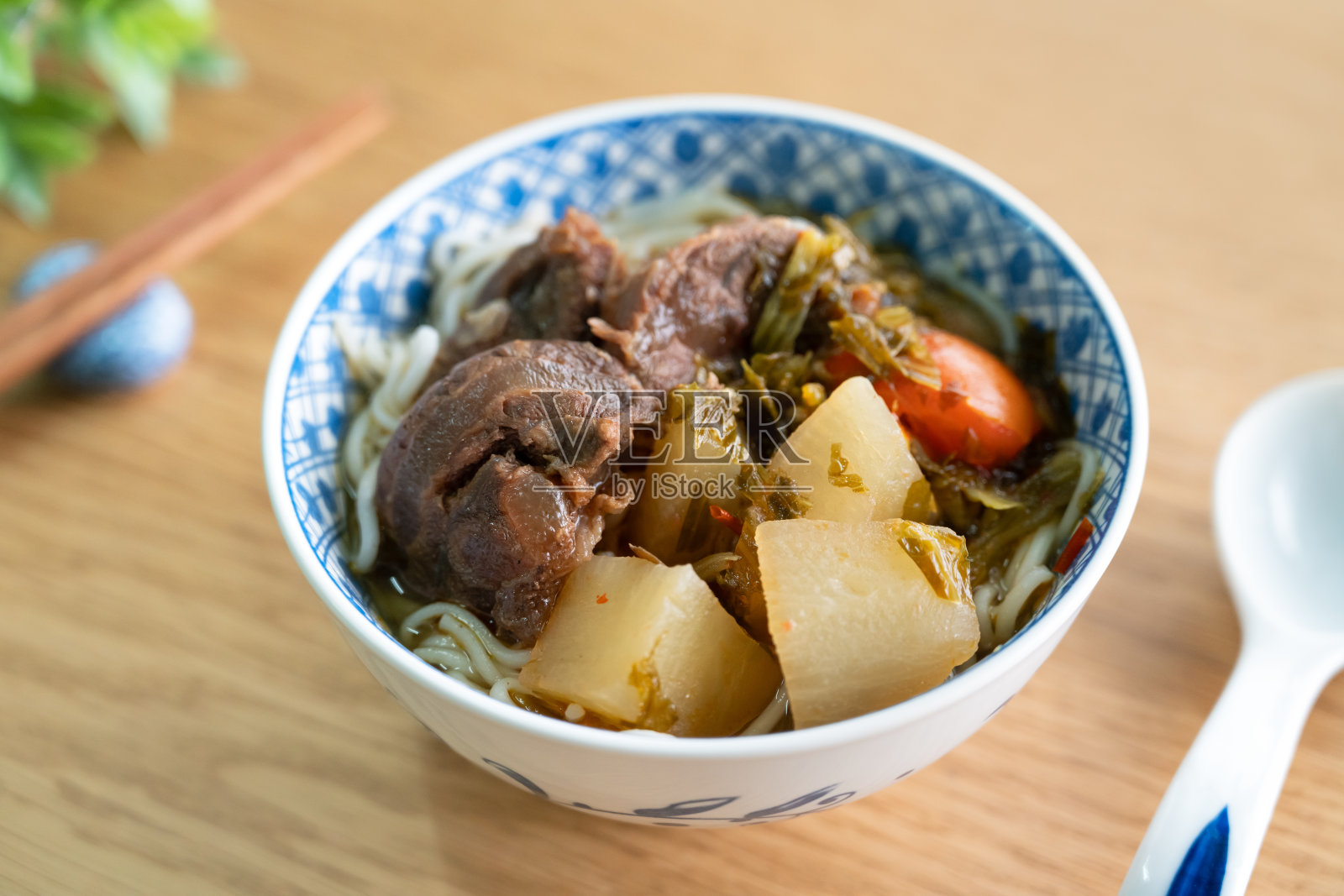 牛肉面汤。台湾名菜放在木桌上的碗里。照片摄影图片