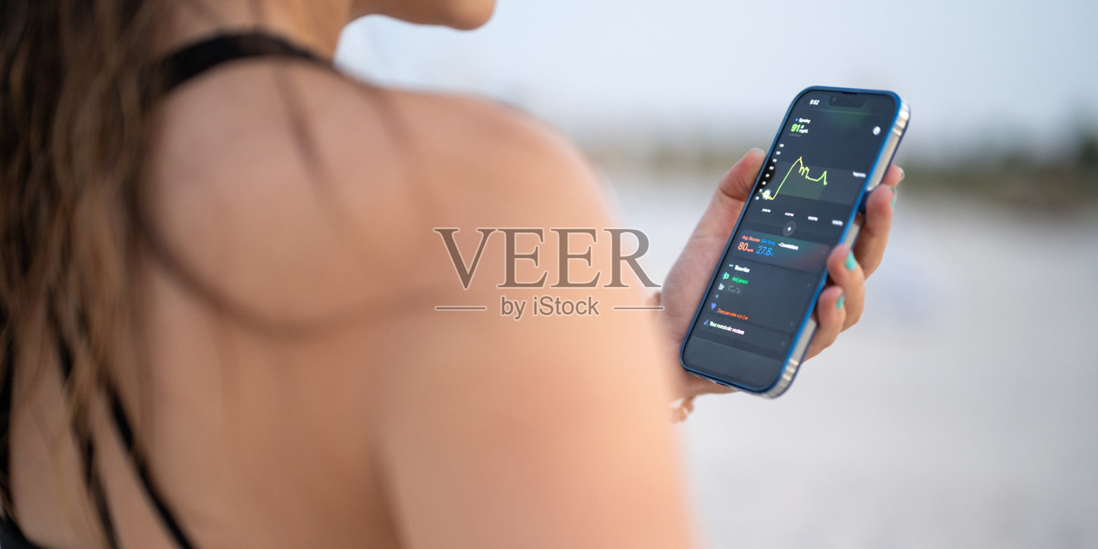 女性使用血糖监测仪控制糖尿病（肩上视角）照片摄影图片