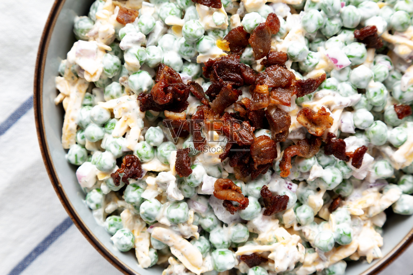 自制奶油培根豌豆沙拉在碗里，俯视图。平躺着，从上面俯瞰。特写镜头。照片摄影图片