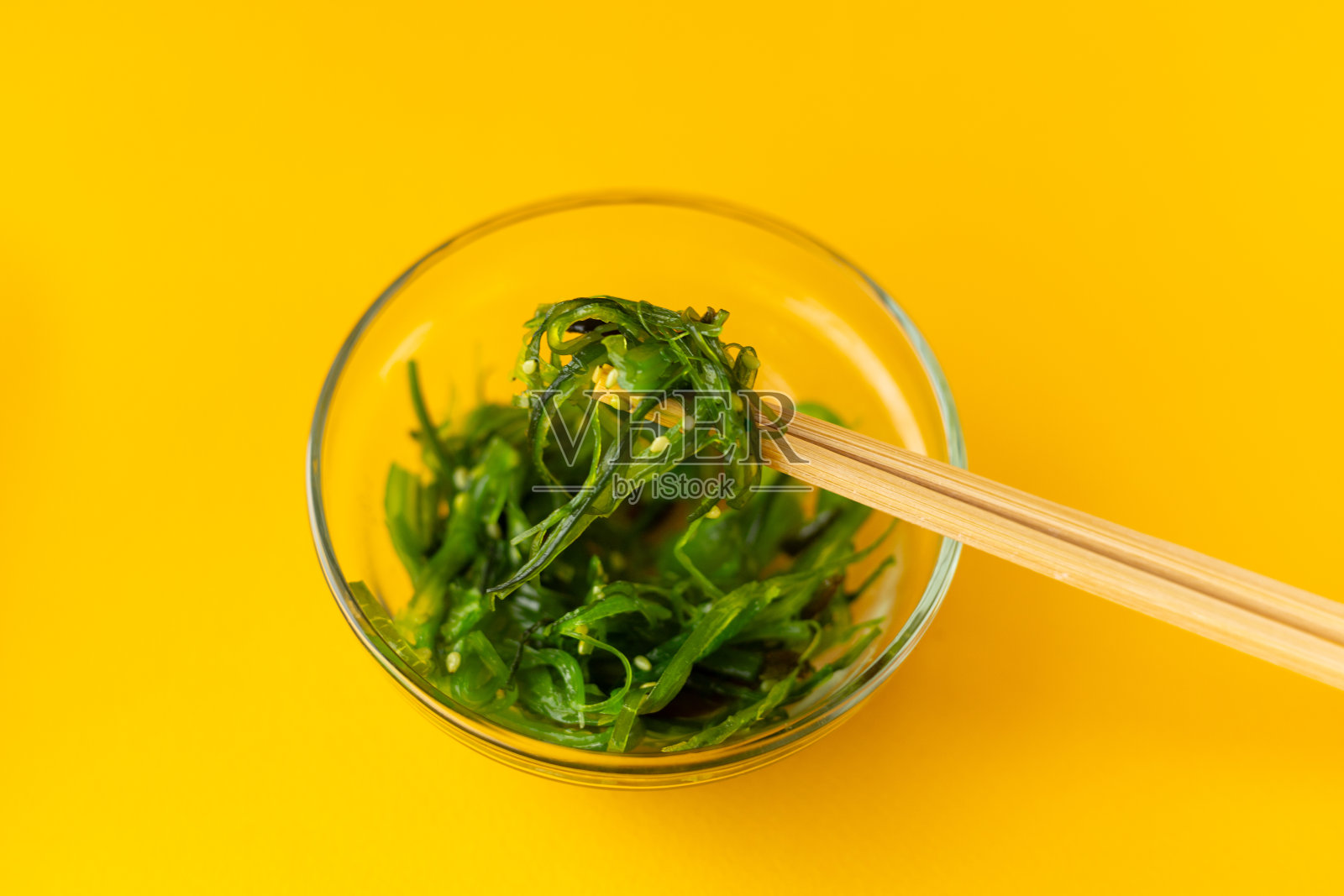 用筷子在玻璃盘里夹沙拉照片摄影图片