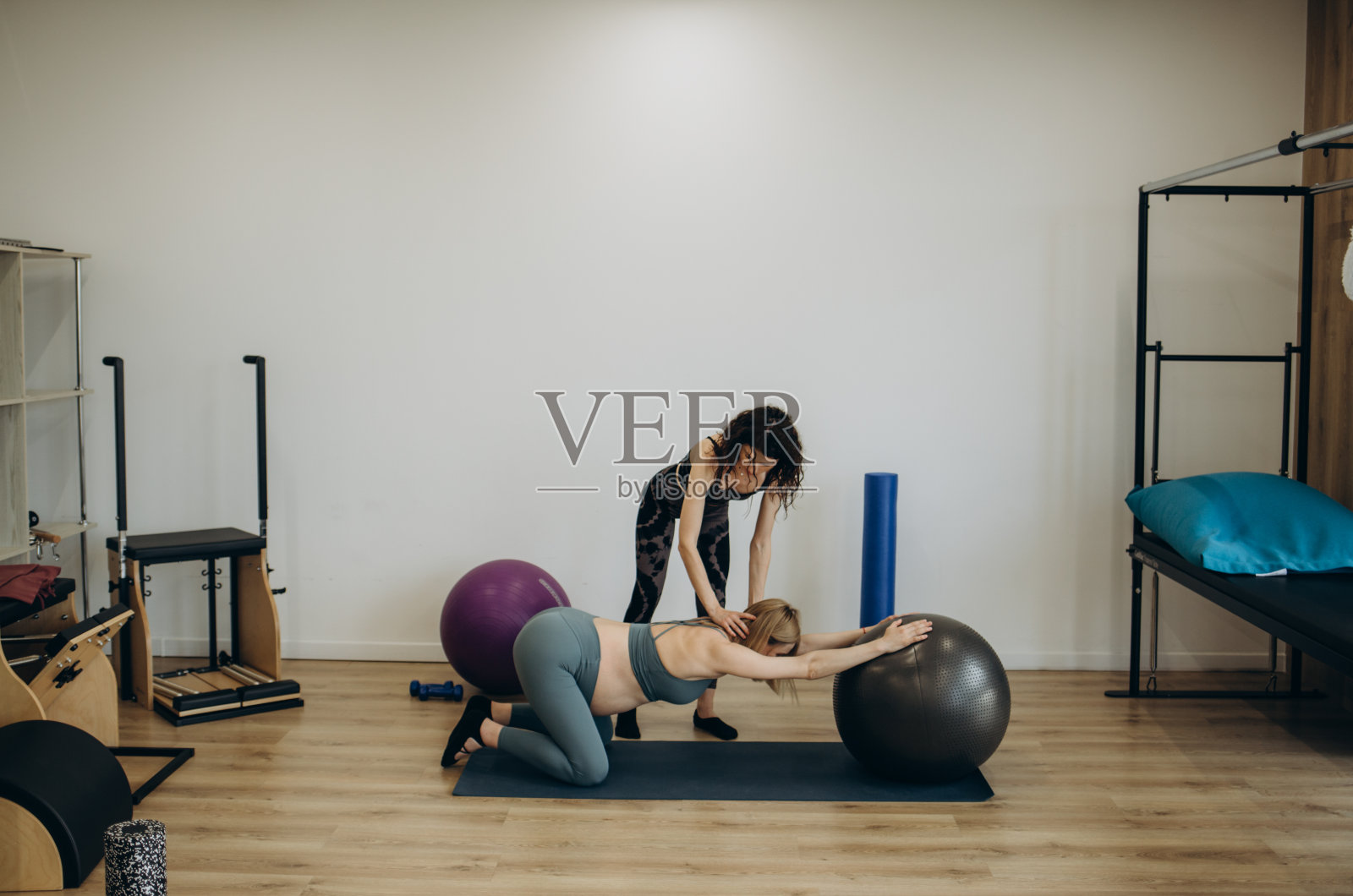 快乐的孕妇训练拉伸教练照片摄影图片