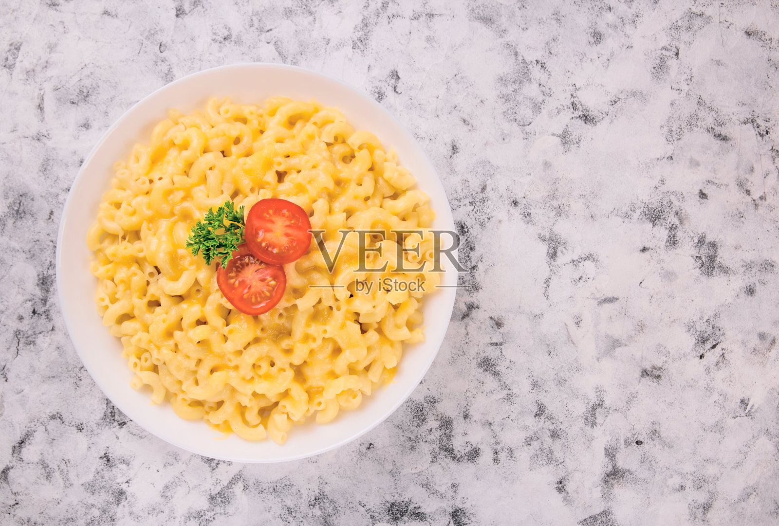 白色盘子里的通心粉和奶酪，配上欧芹和樱桃汤照片摄影图片