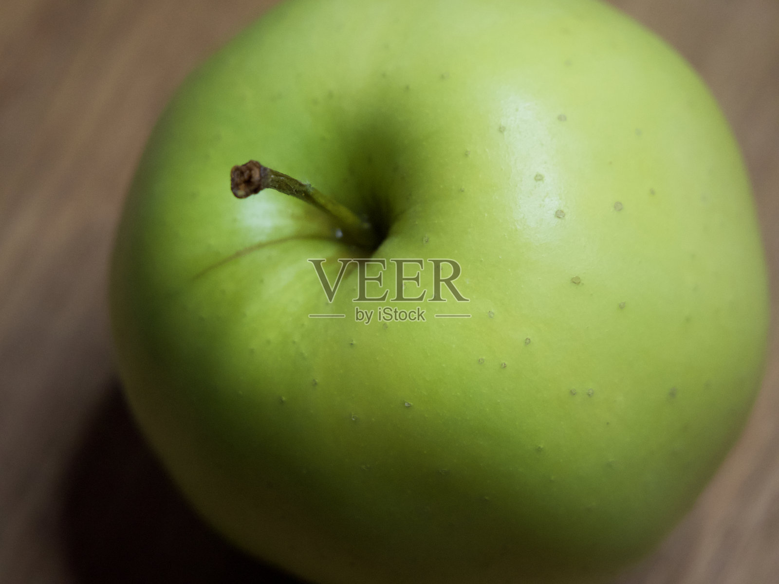 木质表面上的一个金色品种的苹果。特写镜头。照片摄影图片