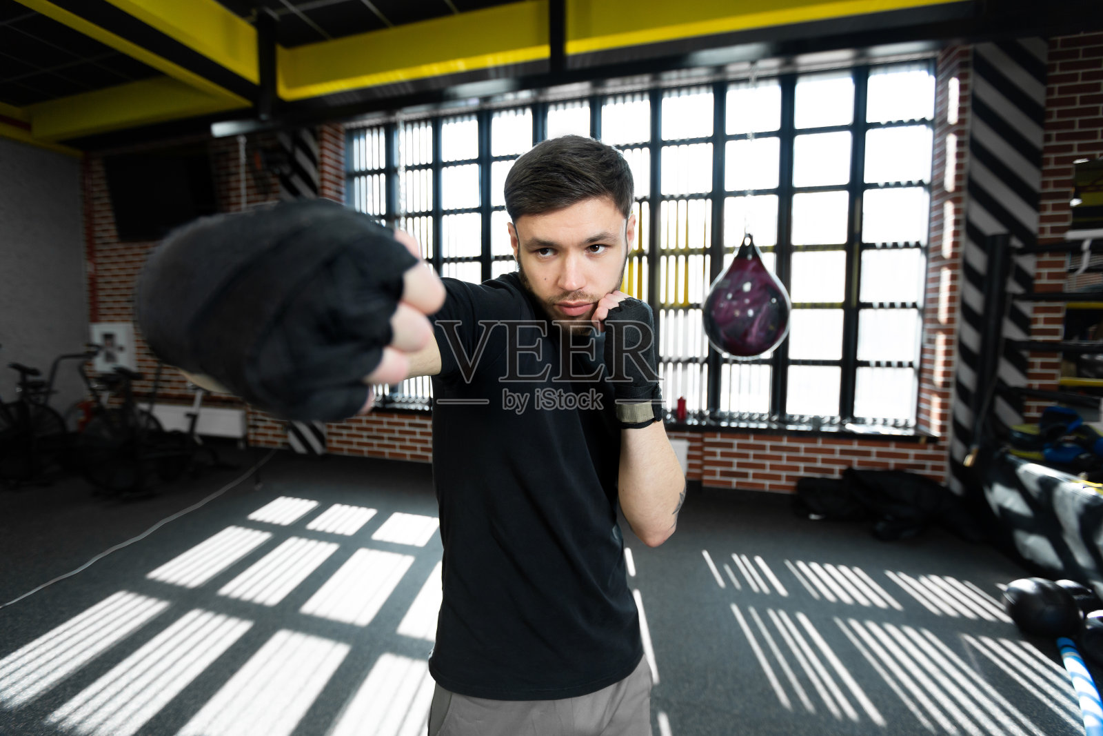 一名年轻的男子自由搏击运动员握紧拳头，在拳击场上训练。照片摄影图片