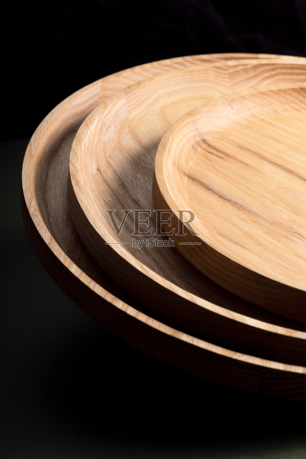 生态餐具的概念。产品适用于现代厨房。自然和谐:环保厨房里的木制盘子。温暖的灯罩。照片摄影图片