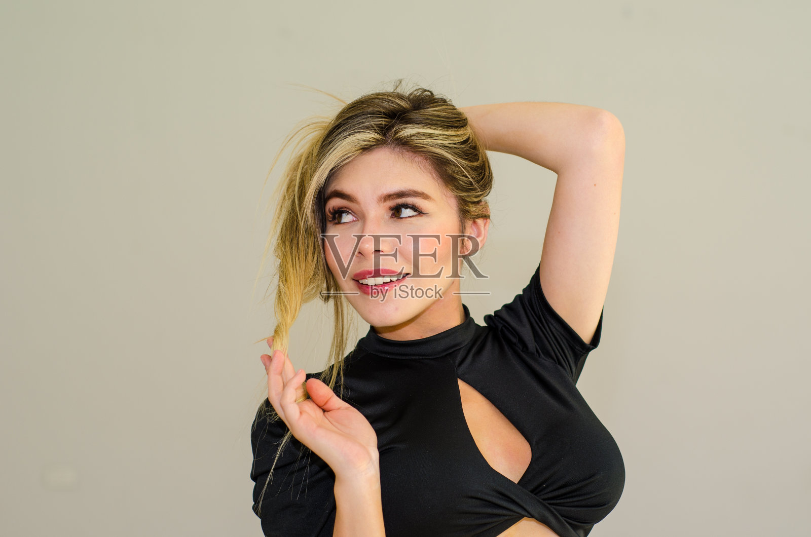 美丽的年轻白人女性的肖像，金发在灰色的背景下摆姿势照片摄影图片