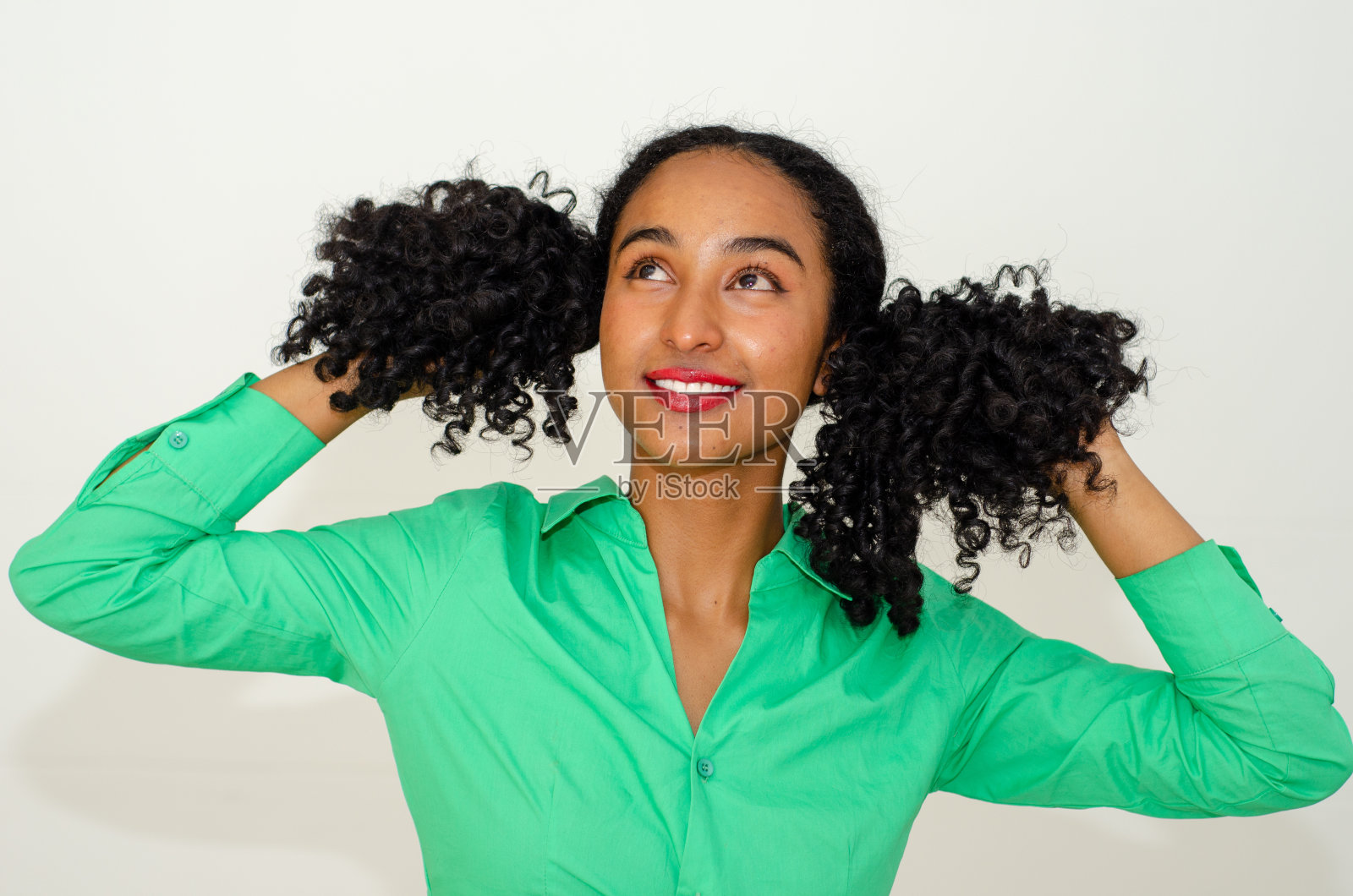 美丽的黑人妇女的肖像在休闲的衣服和玩她的头发在白色的背景照片摄影图片