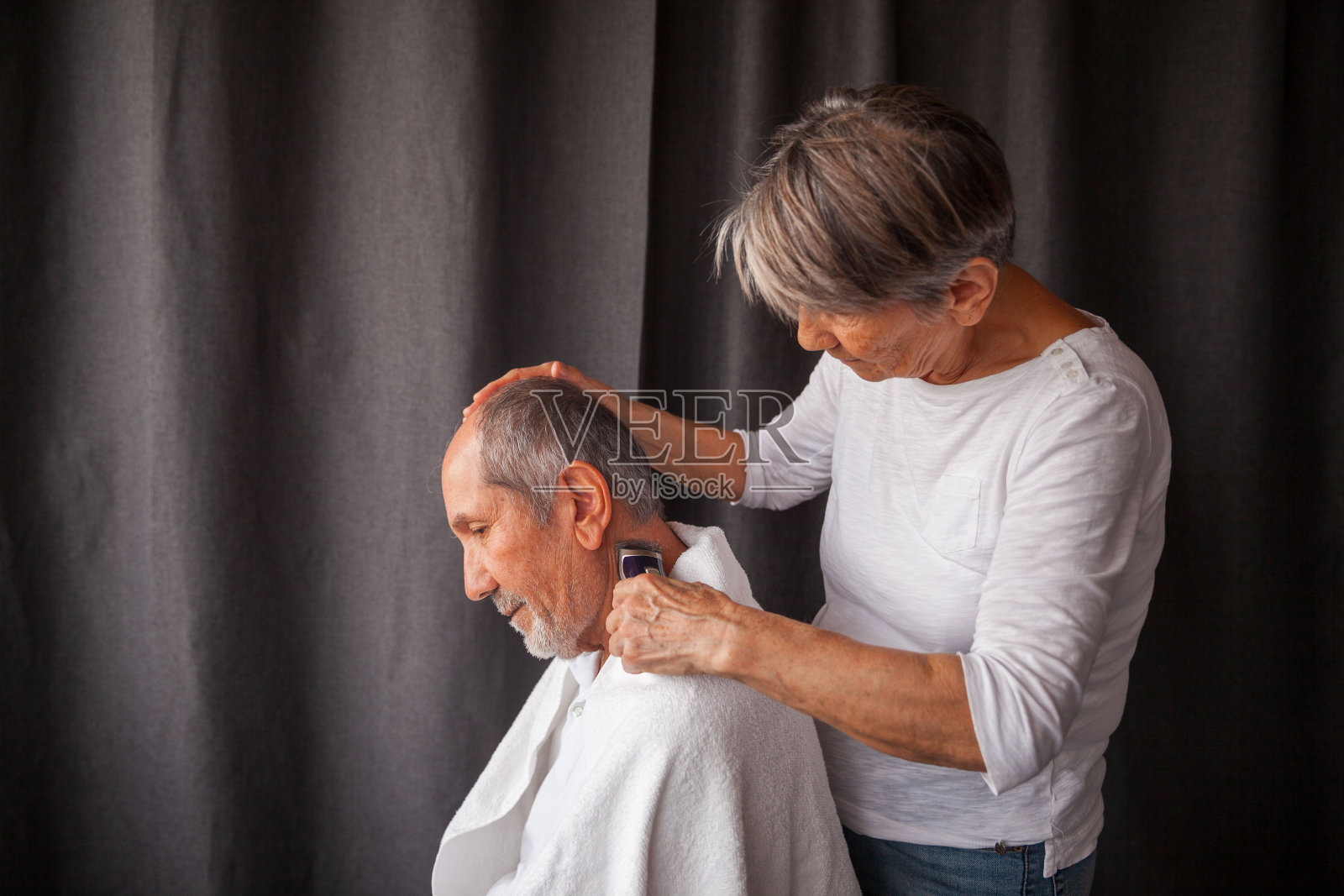 年长的成年妇女剃掉他的头发照片摄影图片