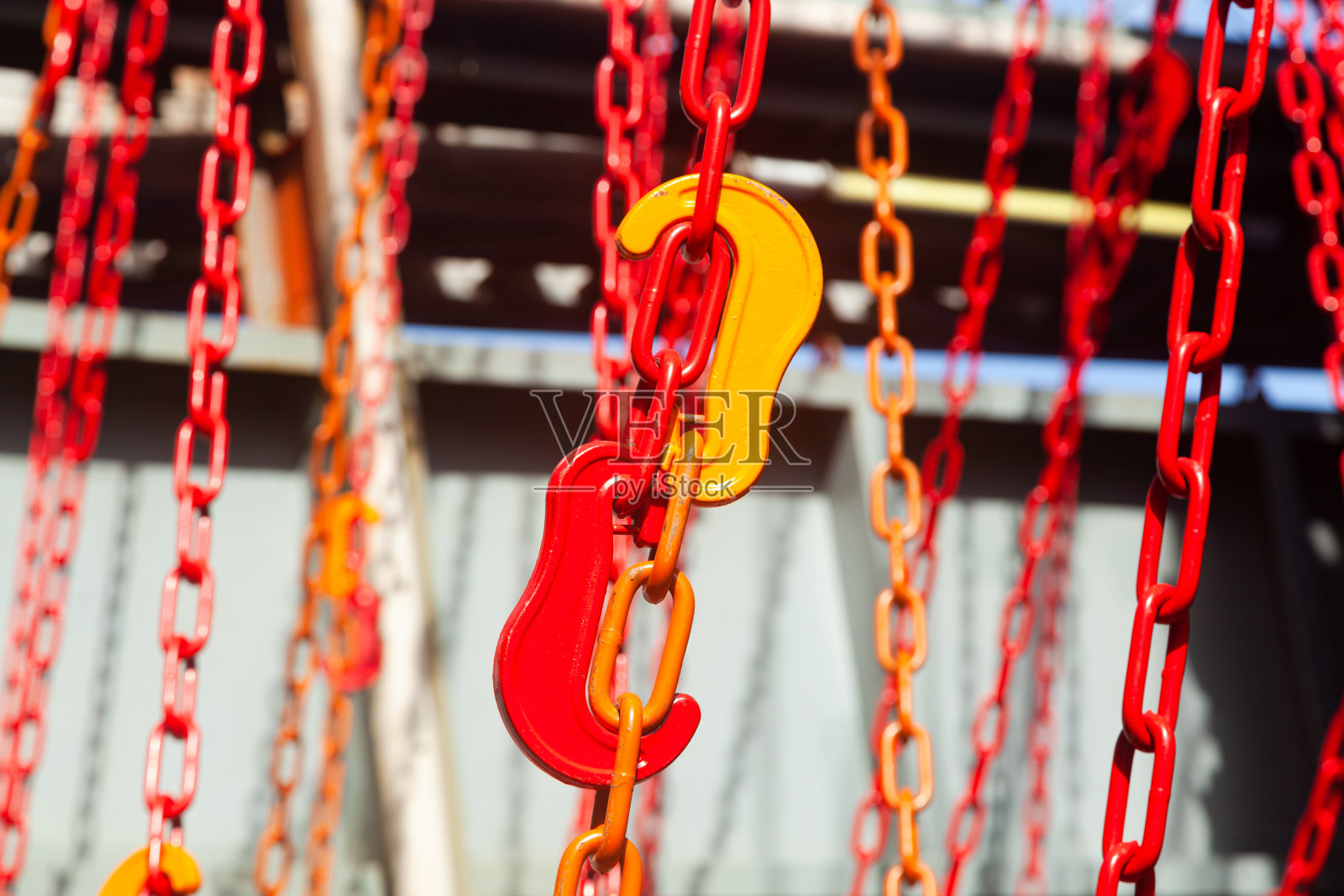 船上拴着许多带钩的红色铁链，用来固定装有货物的集装箱。照片摄影图片