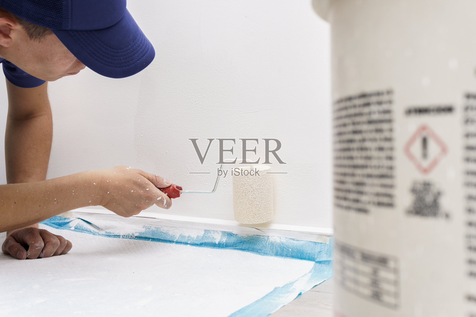 一个男人躺在地板上粉刷房子的墙壁照片摄影图片