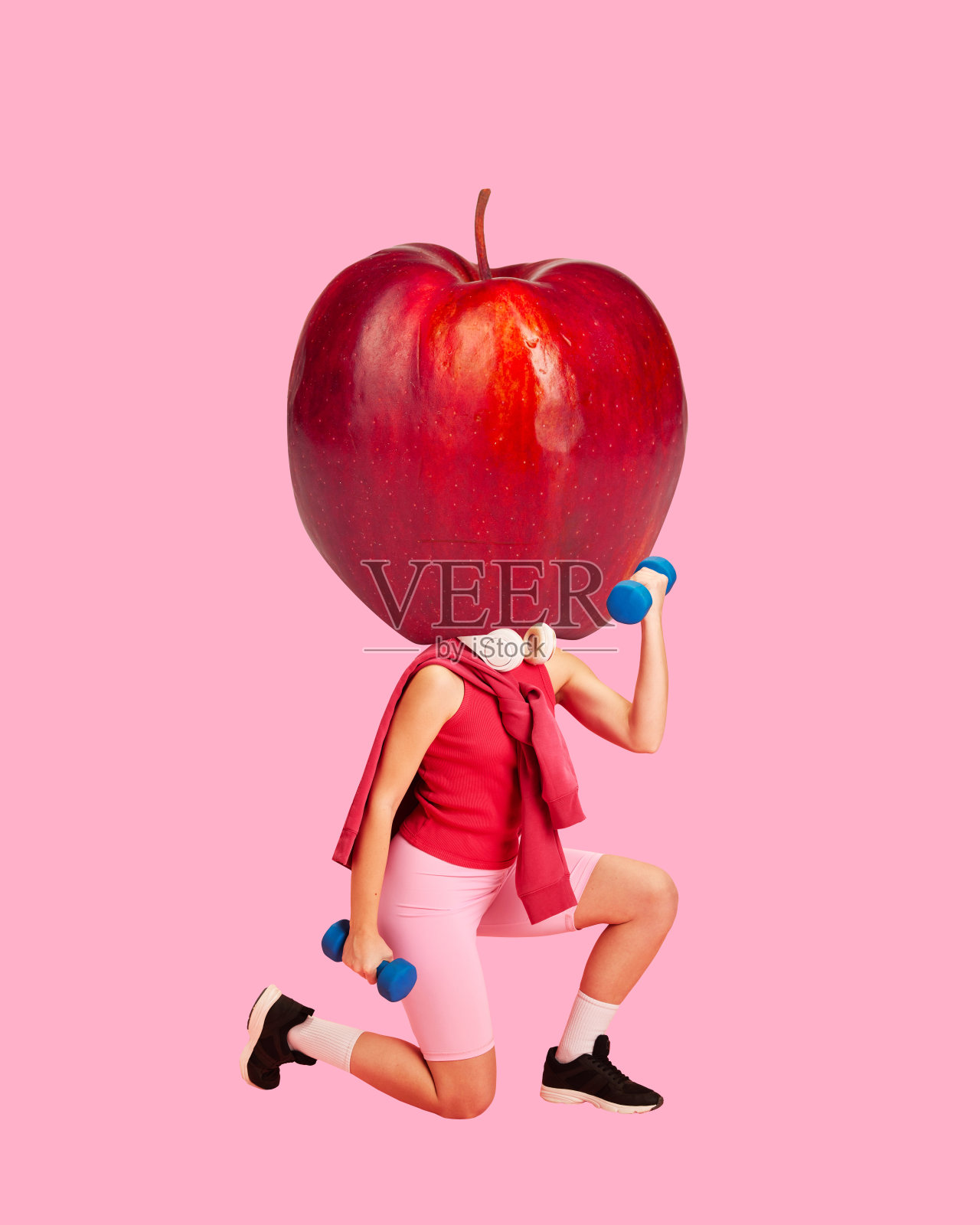 当代艺术拼贴。年轻的运动女性用巨大的苹果代替头部的东练习运动在充满活力的背景下。照片摄影图片