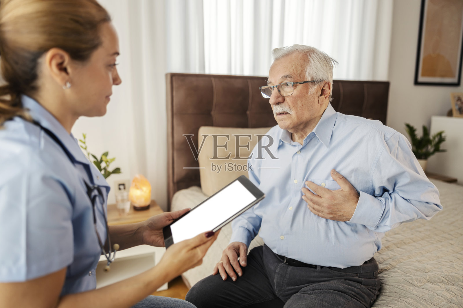 一位老人讲述他的听力疾病的症状，医生正在听他说话。照片摄影图片