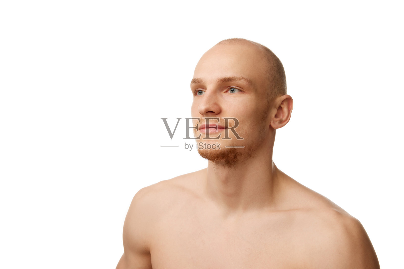 20多岁的英俊秃顶小伙子光着膀子站在一边，孤立地看着白色的摄影棚背景照片摄影图片