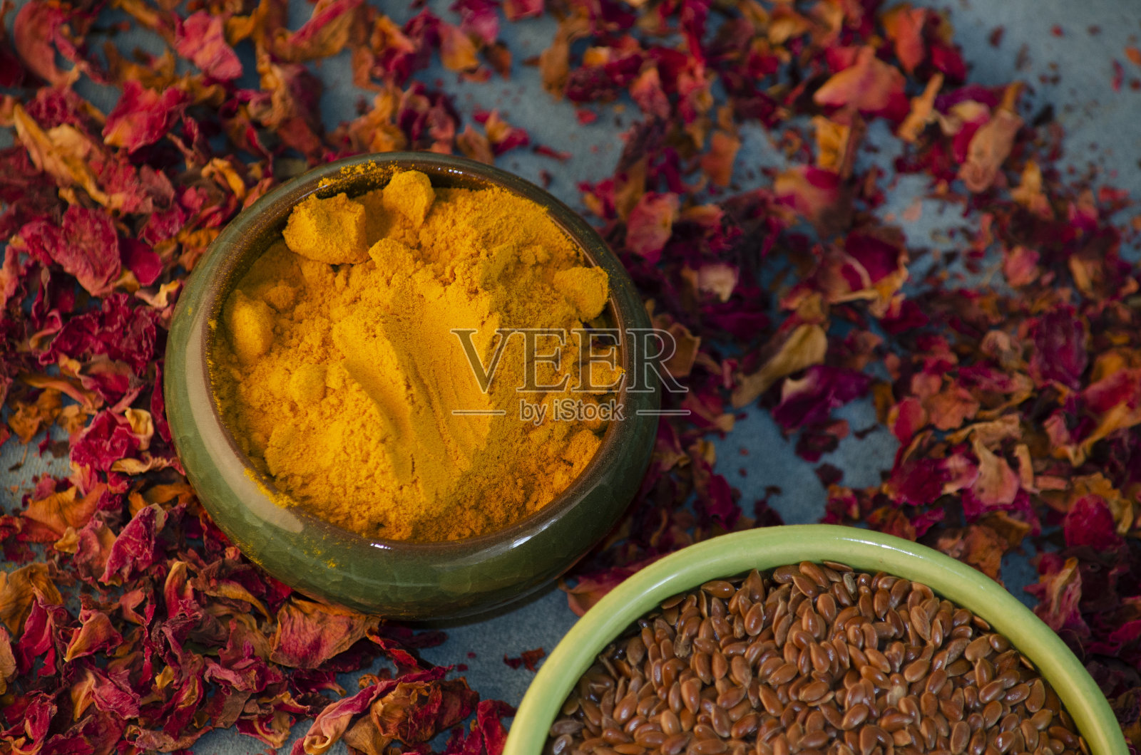 姜黄和芝麻放在碗里，背景是玫瑰花瓣照片摄影图片