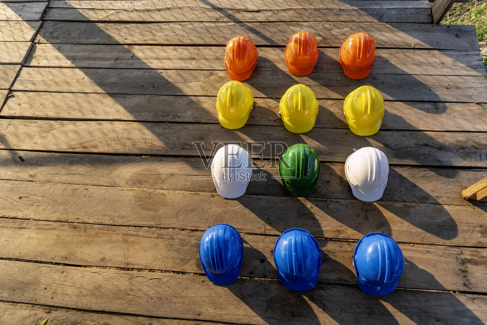 施工安全帽是施工现场工人的安全工具设备，工程防护头挂在木墙上。许多安全帽排钢盔与复制空间。工程建设理念照片摄影图片