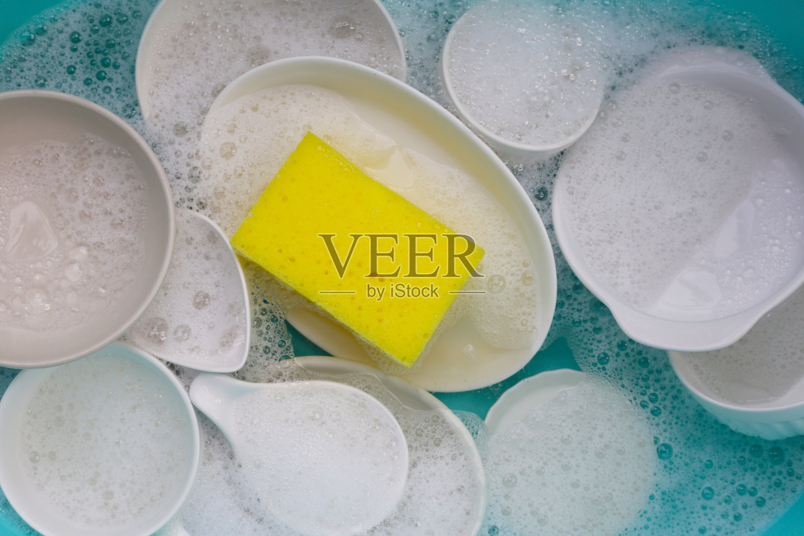 盘子和碗浸泡在洗洁精泡沫中照片摄影图片