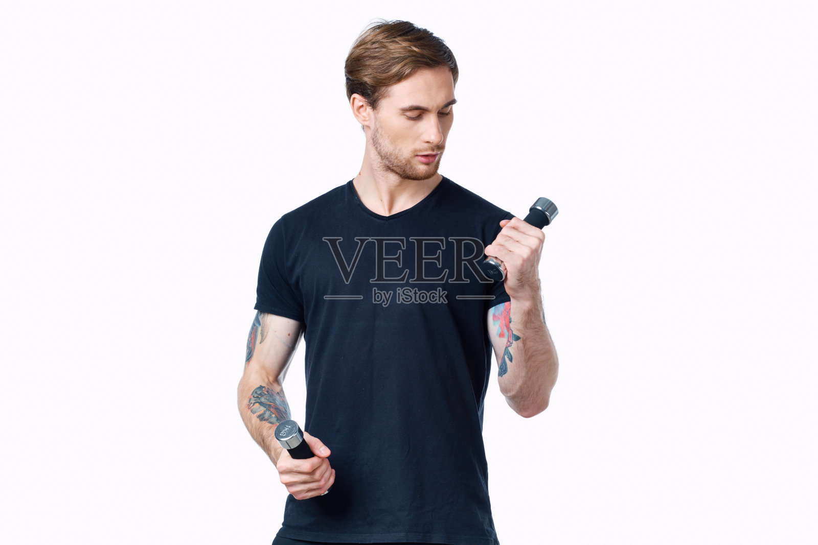 手持哑铃的男运动员在浅色背景裁剪视图上照片摄影图片